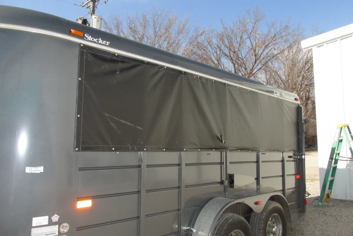 Black trailer with a covered side panel and dual axles.