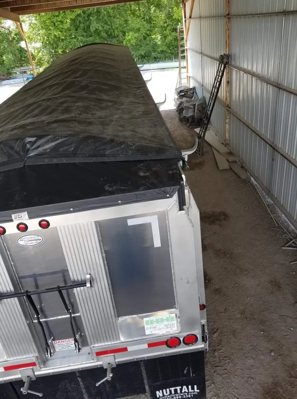 Covered trailer parked inside a storage shed.